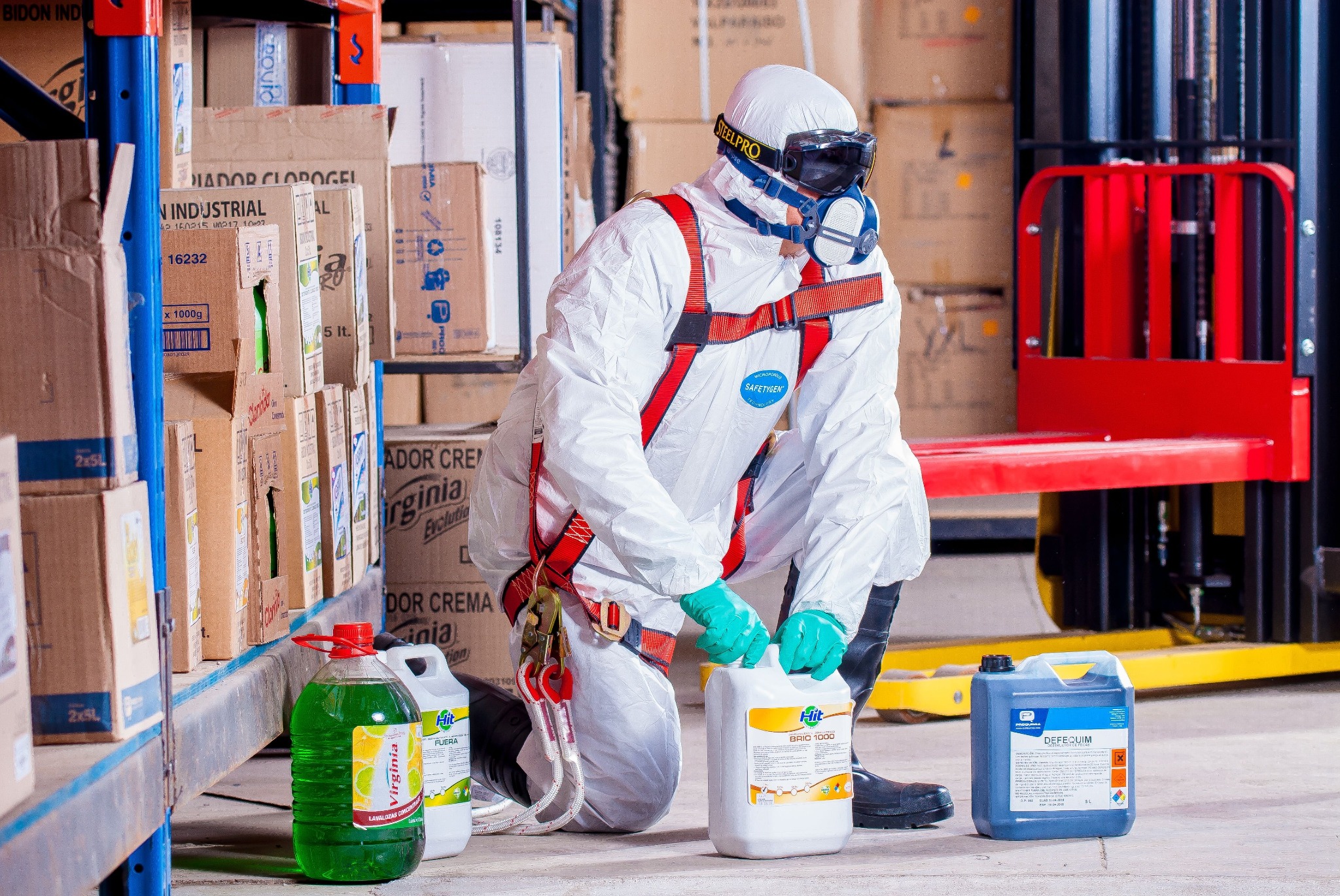 Worker in protective equipment handling containers